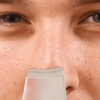 Skin scrubber in use on the face for deep cleansing, exfoliation, and removal of impurities for smoother skin.
